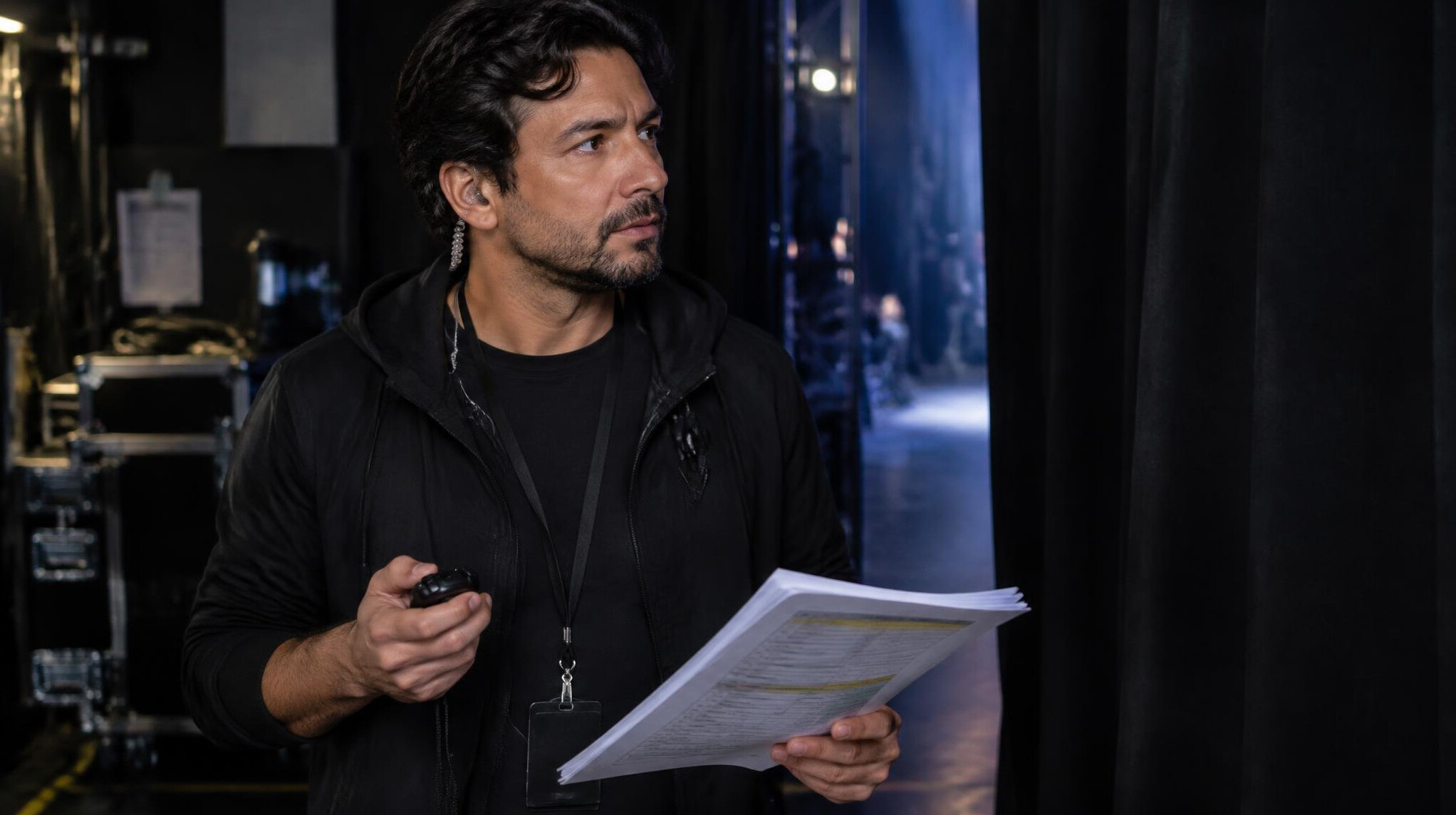 Stage manager holding a script and stopwatch backstage